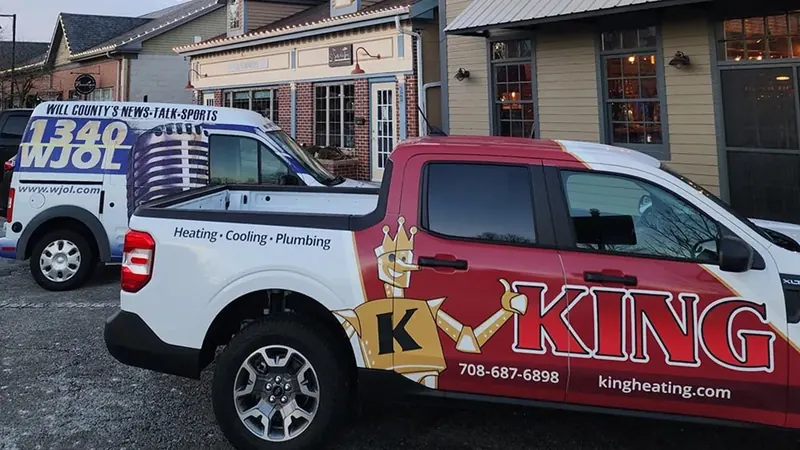 King Heating, Cooling & Plumbing truck next to the 1340 AM WJOL news van