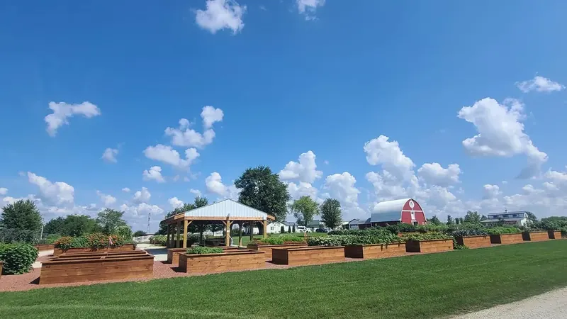 Garden beds, a white tent and a red barn at Navarro Farm in Frankfort